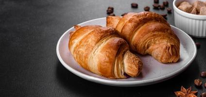 delicioso croissant francés fresco y crujiente con una taza de café aromático foto