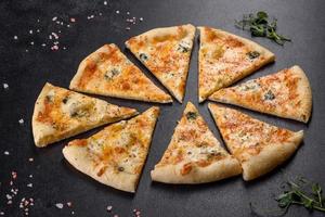 Sabrosa pizza fresca al horno con tomates, queso y champiñones sobre un fondo de hormigón oscuro