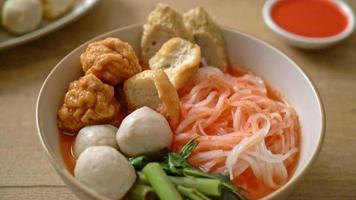 Fideos de arroz planos pequeños con bolas de pescado y bolas de camarones en sopa rosa, yen ta cuatro o yen ta fo - estilo de comida asiática video