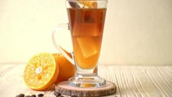 um copo de café preto americano gelado e uma camada de suco de laranja e limão decorado com alecrim e canela video