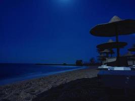 Evening on the beach with straw umbrellas. Hurghada, Egypt photo