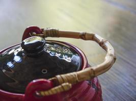 Red Chinese teapot on a wooden table, close-up photo