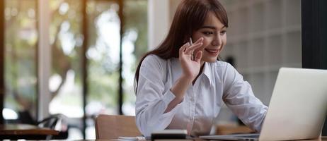 Portrait of a pretty young woman studying while sitting at the table photo