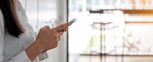 Businesswoman using her smart phone in office photo