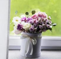 Beautiful flowers in a white round box photo