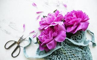 Pink peony flowers in string bag photo