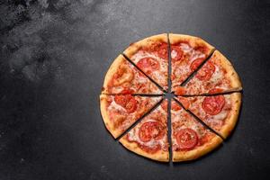 Tasty fresh oven pizza with tomatoes, cheese and basil on a concrete background photo