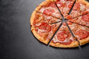 Tasty fresh oven pizza with tomatoes, cheese and basil on a concrete background photo