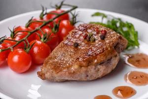 Baked duck breast with herbs and spices on a dark concrete background photo