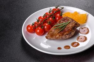 Baked duck breast with herbs and spices on a dark concrete background