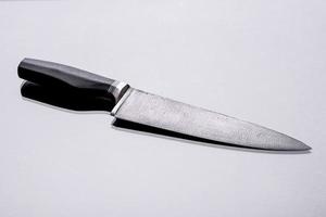 A large handmade hunting knife lying on a dark background photo