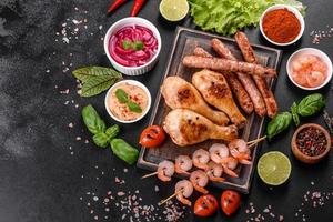 composición de salchichas, pollo, cerdo y camarones preparados a la parrilla, así como verduras preparadas a la parrilla con especias y hierbas foto