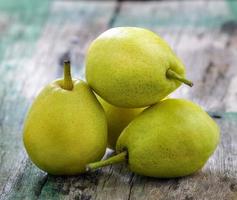 Green pears on a rustic wooden photo