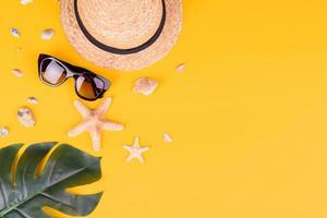 Glasses and hat with shells and sea stars on a colored background photo