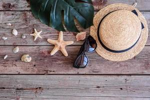 Glasses and hat with shells and sea stars on a colored background photo