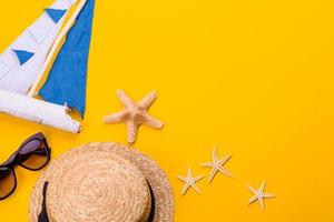 Glasses and hat with shells and sea stars on a colored background photo