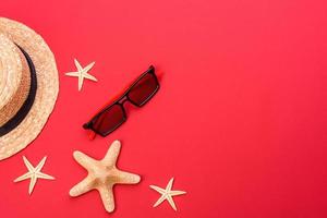 Glasses and hat with shells and sea stars on a colored background photo