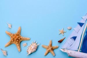 Glasses and hat with shells and sea stars on a colored background photo