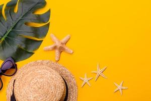 Glasses and hat with shells and sea stars on a colored background photo