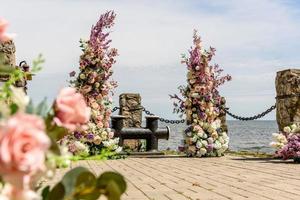 hermosa composición floral para una ceremonia de boda en la costa del océano foto