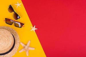 Glasses and hat with shells and sea stars on a colored background photo