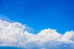 Beautiful white clouds in a bright blue sky on a warm summer day photo