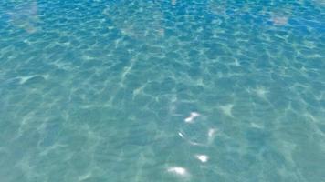 água azul pura cáustica na piscina com reflexos de luz. câmera lenta.