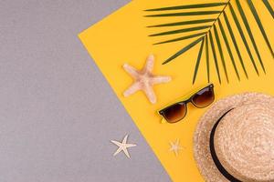 Beach accessories, glasses and hat with shells and sea stars on a colored background. Summer background photo