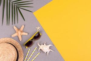 accesorios de playa, gafas y sombrero con conchas y estrellas de mar sobre un fondo de color. fondo de verano foto