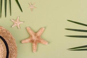 Beach accessories, glasses and hat with shells and sea stars on a colored background. Summer background photo