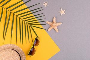 accesorios de playa, gafas y sombrero con conchas y estrellas de mar sobre un fondo de color. fondo de verano foto