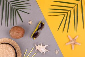 Beach accessories, glasses and hat with shells and sea stars on a colored background. Summer background photo