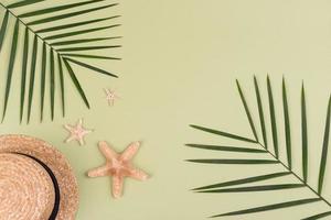 Beach accessories, glasses and hat with shells and sea stars on a colored background. Summer background photo