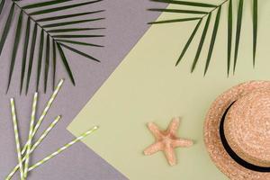 Beach accessories, glasses and hat with shells and sea stars on a colored background. Summer background photo