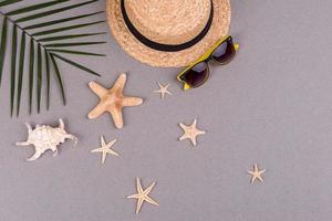 Beach accessories, glasses and hat with shells and sea stars on a colored background. Summer background photo