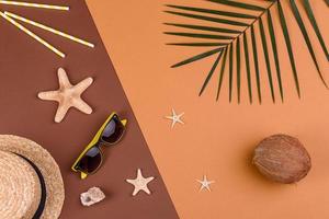 Beach accessories, glasses and hat with shells and sea stars on a colored background. Summer background photo