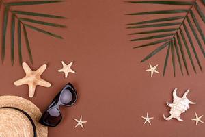 Beach accessories, glasses and hat with shells and sea stars on a colored background. Summer background photo