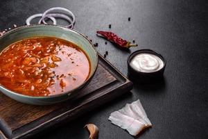 Delicious fresh hot borsch with tomato and meat in a ceramic plate photo
