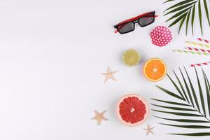 Beach accessories, glasses and hat with shells and sea stars on a colored background photo