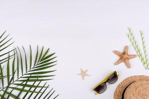 Beach accessories, glasses and hat with shells and sea stars on a colored background photo