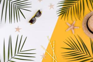 Beach accessories, glasses and hat with shells and sea stars on a colored background photo