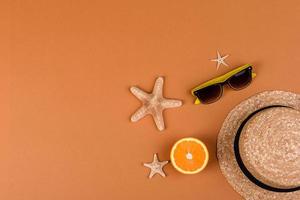 Beach accessories, glasses and hat with shells and sea stars on a colored background photo