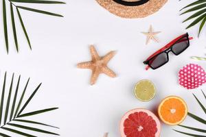 Beach accessories, glasses and hat with shells and sea stars on a colored background photo