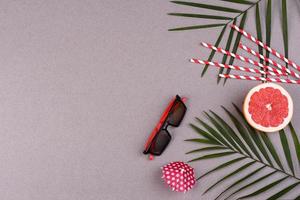 Beach accessories, glasses and hat with shells and sea stars on a colored background photo