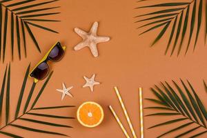 Beach accessories, glasses and hat with shells and sea stars on a colored background photo