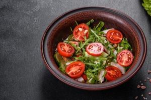 Trozos de pollo, tomates y hojas de lechuga sobre un fondo de hormigón oscuro foto