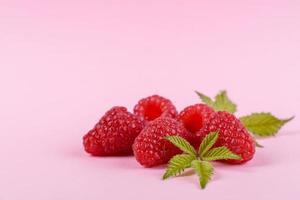 Ripe raspberries with raspberry leaf isolated on a white background photo