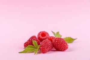 Ripe raspberries with raspberry leaf isolated on a white background photo