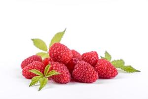 Ripe raspberries with raspberry leaf isolated on a white background