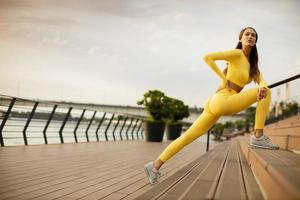 Young woman stretching on the riverside photo